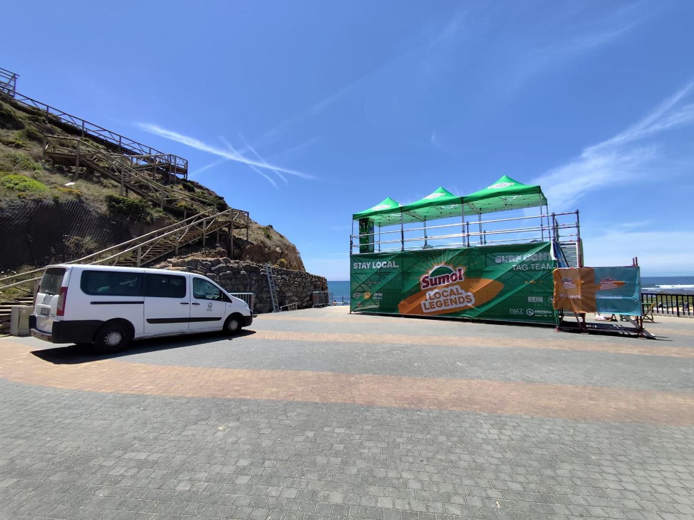 Estrutura de evento concluída, junto à praia, com tendas e lona